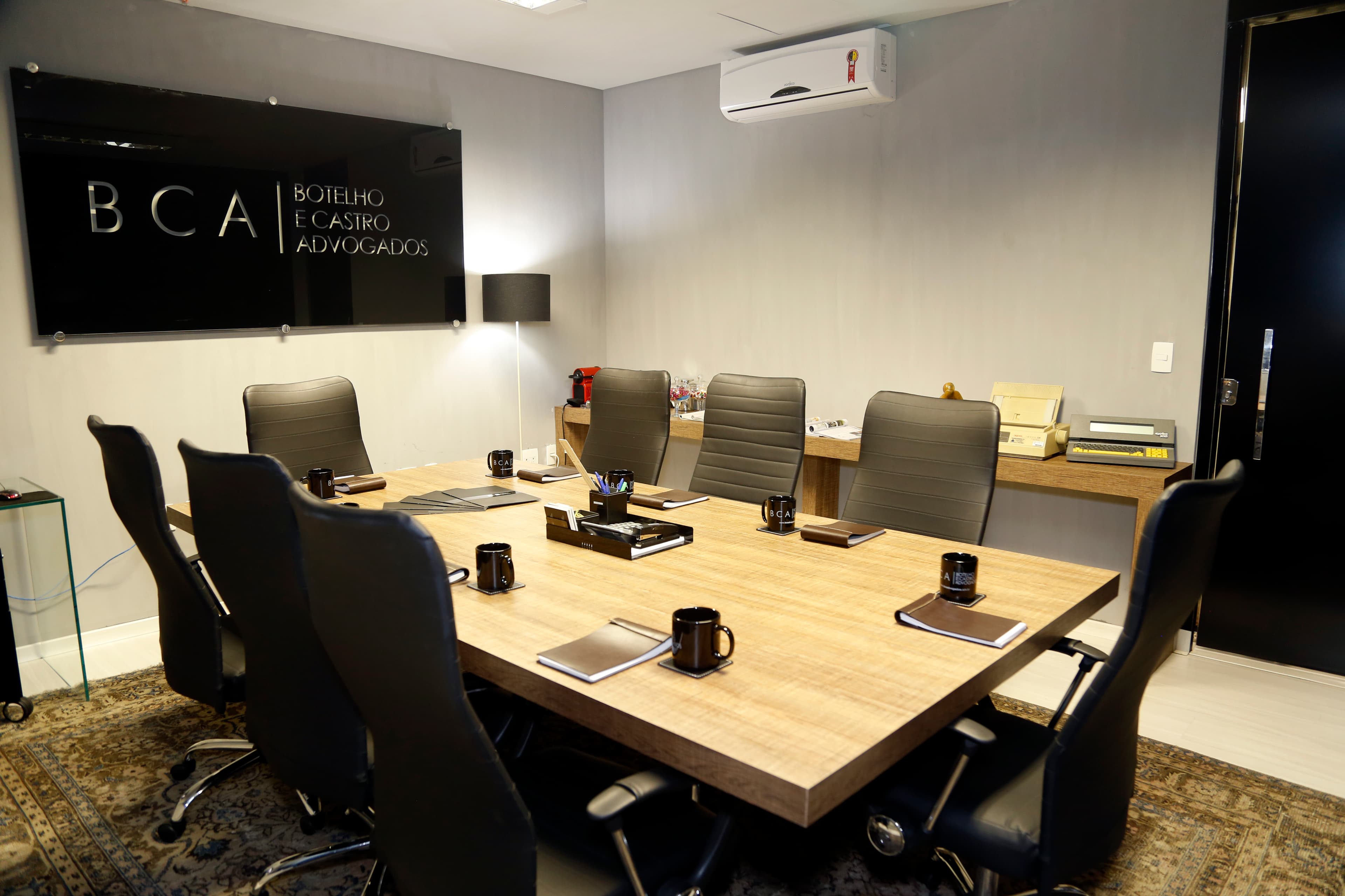 Sala privativa mobiliada com mesa executiva e identidade corporativa